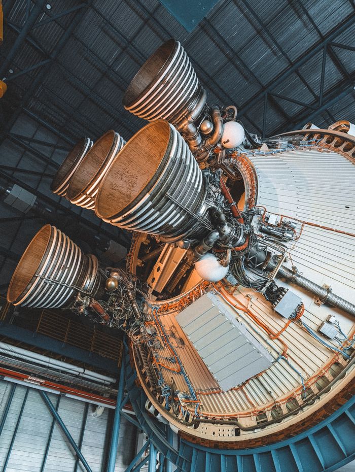 Detailed view of a rocket engine's intricate mechanics showcased in a large indoor facility.